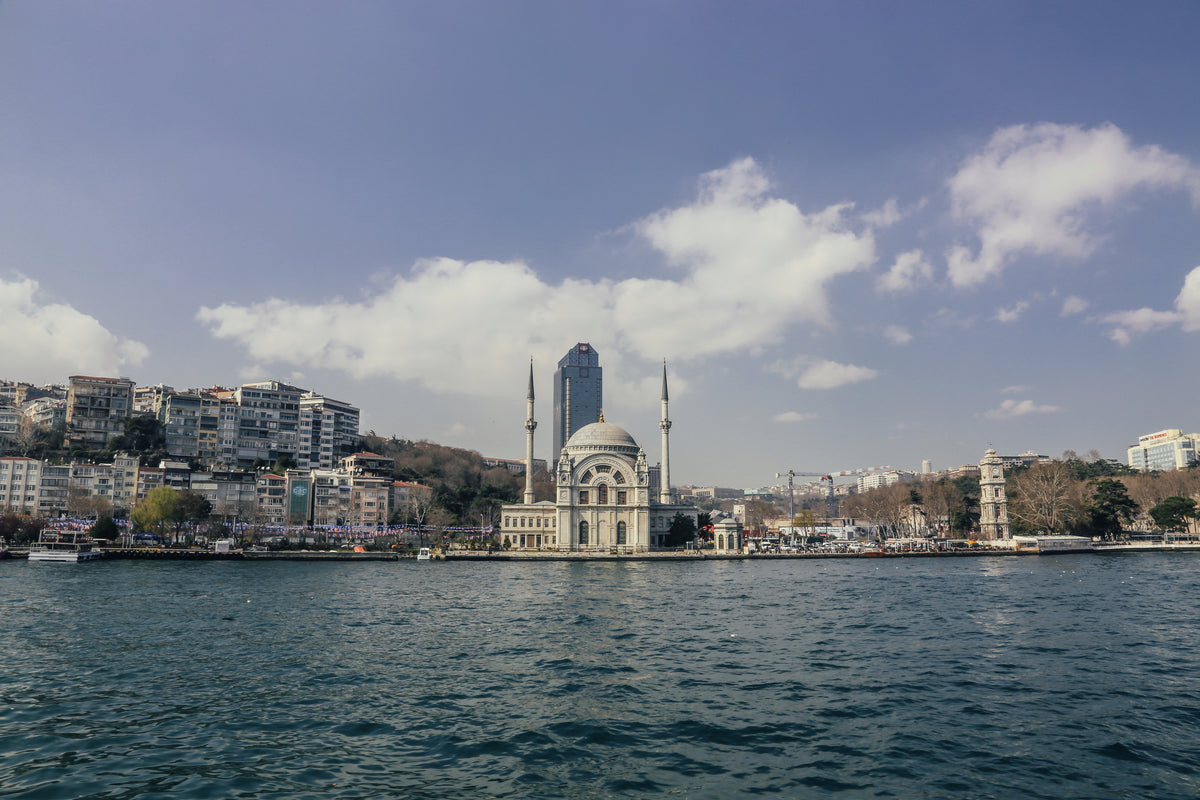Scenic view of Ortaköy Mosque on the Bosphorus in Istanbul, Türkiye, with the waterfront, city skyline, and blue sky, captured during a Bosphorus boat tour.